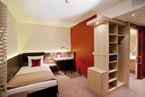 肯普滕阿尔古大盒子酒店的一间卧室配有一张床和一张书桌