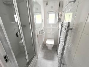 伦敦Beautifully refurbished 5-bed - Great Transport - Free Parking (sleeps 12)的白色的浴室设有卫生间和淋浴。