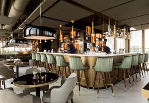 埃因霍温NH埃因霍温中心酒店的餐厅设有酒吧,配有桌椅