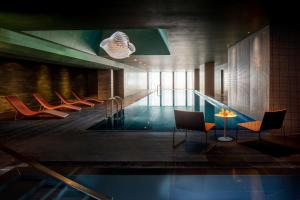都柏林Anantara The Marker Dublin- A Leading Hotel of the World的大楼内一个带椅子和桌子的游泳池