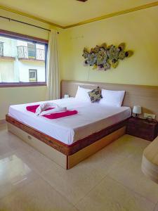 卡兰古特Shradha luxury room的一间卧室配有一张带白色床单的大床