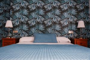 两姐妹蒙诺酒店的一间卧室配有蓝色的床和植物墙