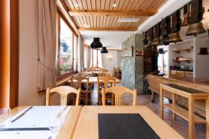 威拉尔-苏-罗伦阿尔卑斯如花酒店的用餐室设有桌椅和窗户。