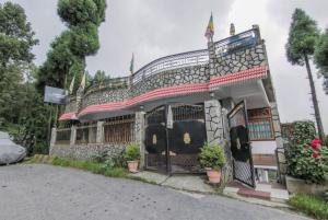 GhumGRG Tharbaling Homestay Darjeeling的前面有门和盆栽植物的建筑