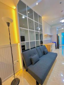 棉兰Apartemen 2BR Podomoro Lincoln Delipark Medan的客厅里设有蓝色沙发