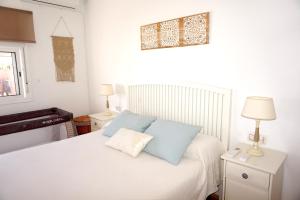 桑卢卡尔-德巴拉梅达Villa Horacia的一间卧室配有白色床和蓝色枕头