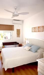 桑卢卡尔-德巴拉梅达Villa Horacia的卧室配有白色的床和吊扇