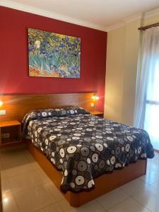 多列毛利诺斯玛利亚德尔卡门公寓酒店的卧室配有一张床,墙上挂有绘画作品
