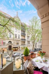 柏林选帝侯大街奥古斯塔酒店的城市街道上带桌椅的阳台