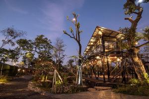 Ban Khlong NungNa Klongluang Boutique Resort的夜晚有灯的树屋