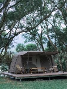 深圳NatureLand望桐露营地的田野上带桌椅的帐篷