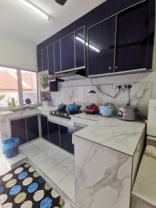 马日丹那Homestay MdmMai Private Pool的厨房配有蓝色橱柜和台面