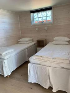 南雪平Lyxiga stugor med sjöutsikt的带窗户的客房内设有两张单人床。