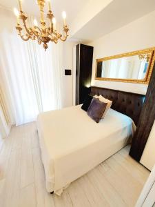 维罗纳Piccolo Mondo Verona的一间卧室配有一张带镜子和吊灯的床。