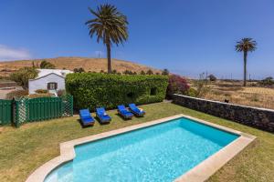 Los VallesCasa El Barranco的一个带两把椅子的游泳池,一个棕榈树