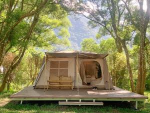 深圳NatureLand望桐露营地的树林里的一个帐篷,里面摆放着两把椅子