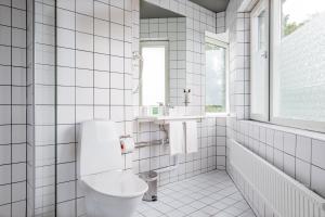 乌普兰斯韦斯比Hotel Stockholm North by FIRST Hotels的白色瓷砖浴室设有卫生间和水槽
