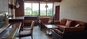 清迈太平洋时尚酒店的客厅配有沙发、椅子和桌子