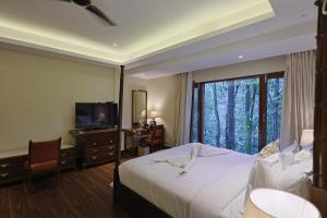 德拉敦Punarnava Wellness Resort & Spa的酒店客房,配有床和电视