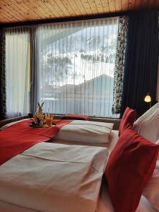 上陶恩Hotel Bella的一间卧室设有两张床和一张桌子,上面摆放着兔子