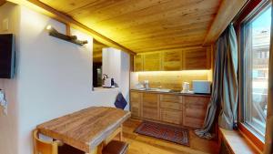 席尔瓦普拉纳Abitaziun Güglia - Silvaplana的厨房配有木制橱柜和木桌。