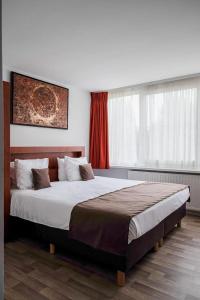 布鲁日Hotel Olympia in Bruges的一间卧室设有一张大床和一个窗户。