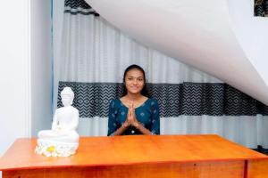 拜蒂克洛East Gate 8-9 Batticaloa的女人站在桌子前,有雕像