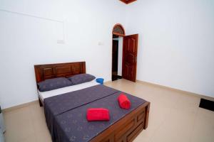 拜蒂克洛East Gate 8-9 Batticaloa的一间卧室配有一张带两个红色枕头的床