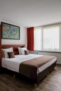 布鲁日Hotel Olympia in Bruges的一间卧室设有一张大床和一个窗户。