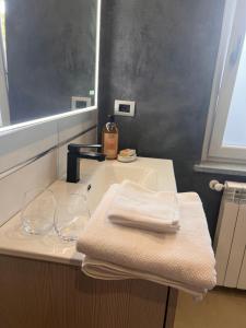 伊夫雷亚Le camere del Cappello Verde的一间带水槽、两条毛巾和镜子的浴室