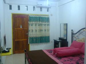 英德Dasi Guesthouse的一间卧室设有一张床、一扇门和一扇窗户