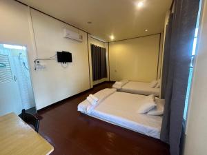 黎府โฮมสเตย์ภูมิใจ เชียงคาน ซอย 17的一间酒店客房,设有两张床和电视