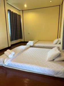黎府โฮมสเตย์ภูมิใจ เชียงคาน ซอย 17的配有2张床的带白色床单和枕头的客房