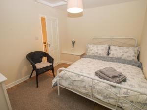 什鲁斯伯里Bluebell's Cottage的一间卧室配有一张床和一把椅子