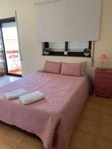 卡米尼亚houses&halfhouses historic street的一间卧室配有粉红色的床和2条毛巾