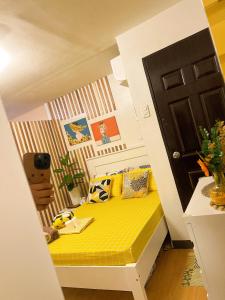 MarilaoBulacan Staycation At Urban Deca Homes Marilao的一间小卧室,房间内设有一张黄色的床