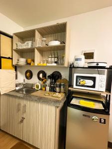 MarilaoBulacan Staycation At Urban Deca Homes Marilao的厨房配有微波炉和冰箱。