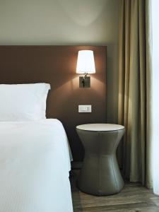 莫利亚诺威尼托MOVE Hotels Venezia Nord的一间卧室配有一张床,墙上配有一盏灯