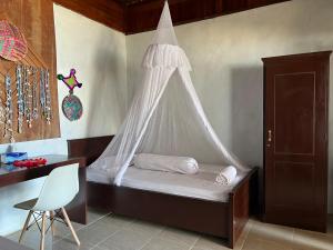 TapokrengMangkombong Homestay的一间卧室配有一张带蚊帐的床