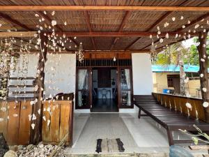 TapokrengMangkombong Homestay的门廊设有木制天花板和长凳