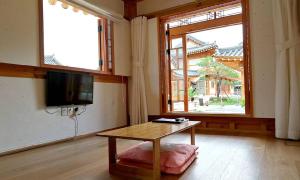庆州Hwangnamguan Hanok Village的客厅配有桌子和电视