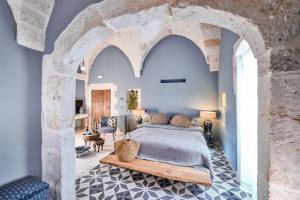 法萨诺Bambarone La Masseria的一间卧室设有一张特大号床和石墙
