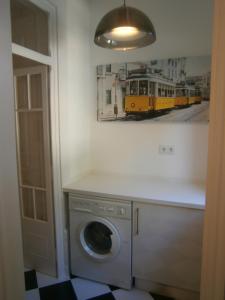 里斯本明星公寓的一张有火车照片的房间里的洗衣机