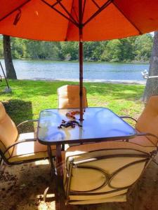 温泉城Perfect Lake Retreat的湖畔遮阳伞下的桌椅