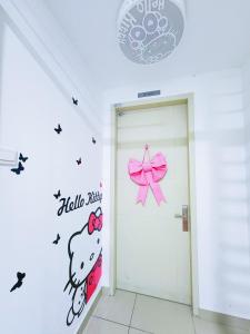 普崇Puchong HELLO KITTY FULLY AIR-CON Suite的一间设有门的房间,配有一个猫猫猫的壁贴