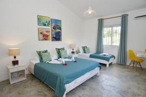 Rodrigues IslandRodrigues Holiday Family Villa Zourit的一间卧室配有两张床、一张桌子和一把椅子