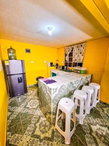 普罗维登西亚Posada Hostel Adri的厨房设有黄色的墙壁和带凳子的柜台。