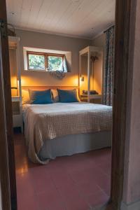 瓦克斯霍尔姆瓦克斯霍姆公寓的一间卧室配有一张带蓝色枕头的床和一扇窗户。