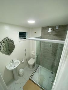 曼加拉蒂巴Pousada Lisamar的一间带玻璃淋浴和卫生间的浴室
