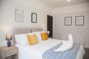 沃勒西8 Karslake Road的卧室配有一张带黄色枕头的大型白色床。